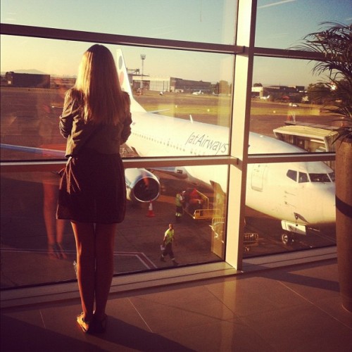 Как сэкономить на покупке авиабилетов, девушка смотрит в окно в аэропорту