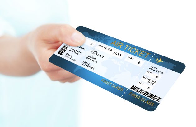 blue fly air ticket holded by hand over white background