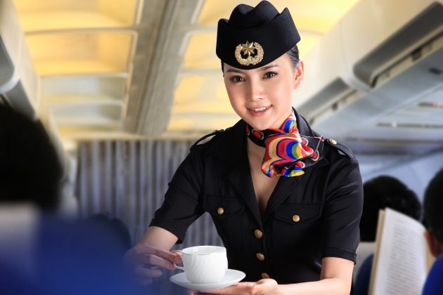 Flight attendant serving people on airplane