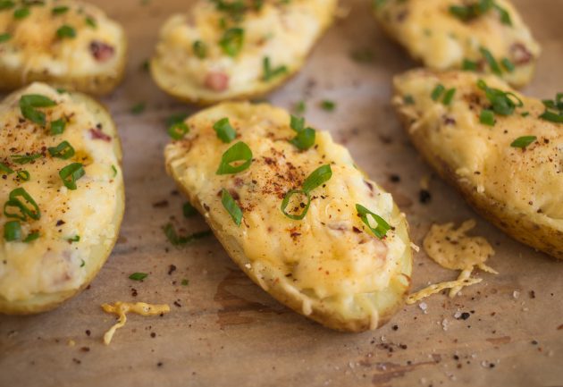 Посыпьте зеленью фаршированный картофель с сыром и беконом 