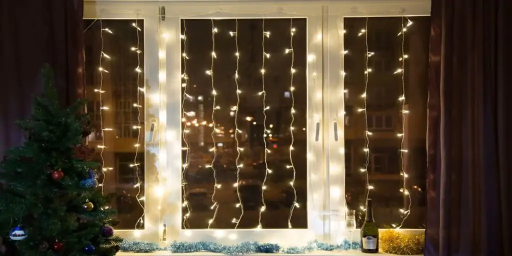 Как красиво повесить гирлянду: светящийся занавес на окне
