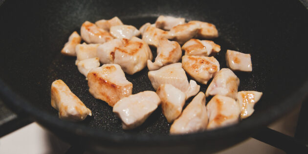 Фунчоза с курицей и овощами: Разогрейте в сковороде масло и обжаривайте филе