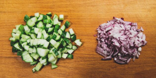 Салат с тунцом, яйцами, огурцами и кукурузой: нарежьте лук и огурцы
