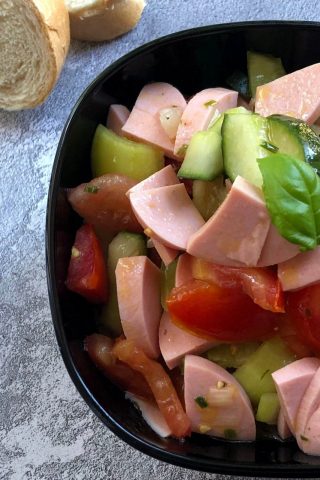Салат с помидорами, огурцами, колбасой и пикантной заправкой