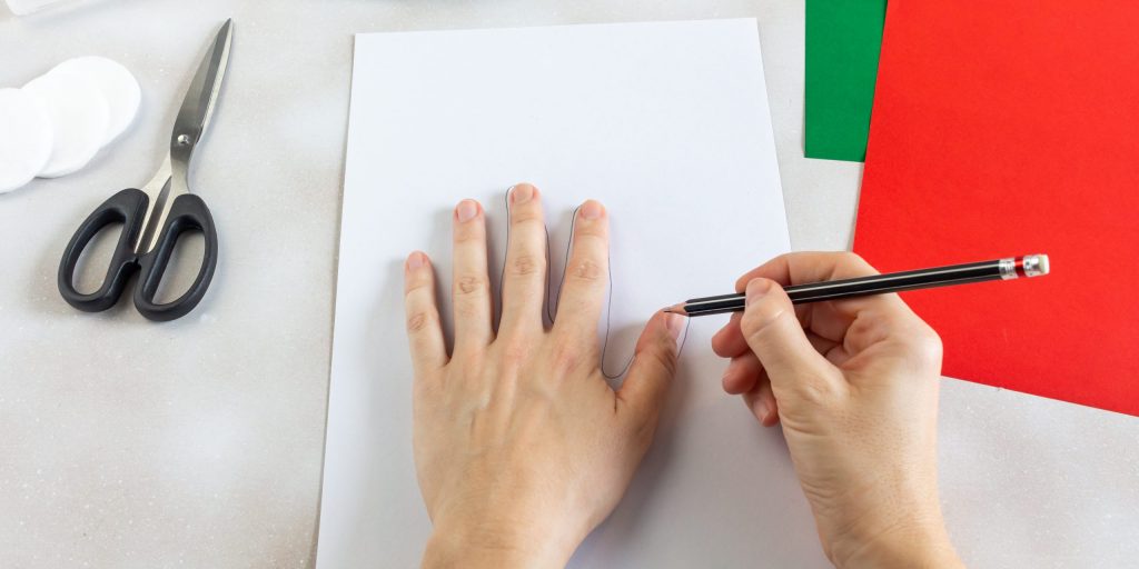 Венок из отпечатков рук: приложите ладонь к листу бумаги и обведите её карандашом. Вырежьте отпечаток ножницами