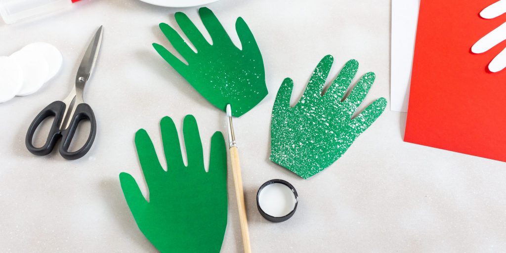 Нанесите на кончик жёсткой кисти немного белой гуаши. Сбрызните часть ладоней краской