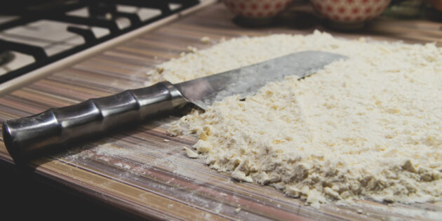 Рецепт рогаликов с орехами и изюмом: Масло или маргарин натрите на тёрке или нарежьте небольшими кубиками и ножом порубите с мукой