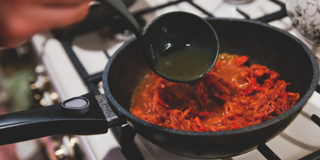 Как приготовить красный борщ с говядиной: Вмешайте томатную пасту в зажарку и влейте к овощам 2–3 половника бульона