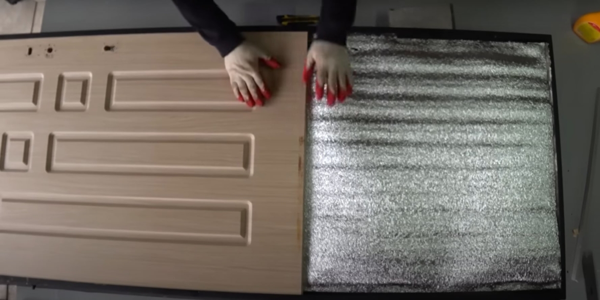 человек утепляет входную дверь своими руками