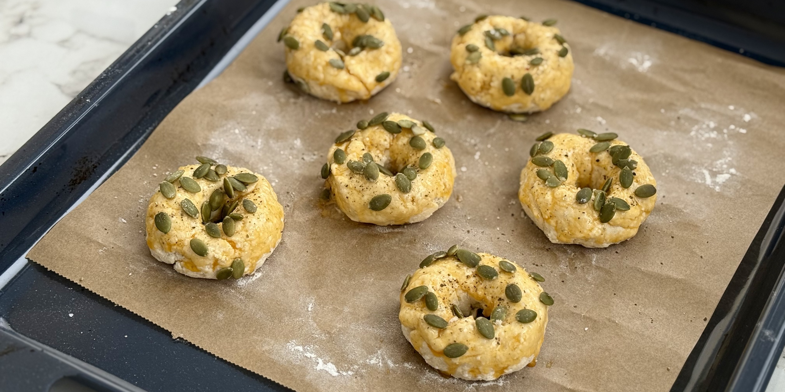 Смажьте бейглы желтком и посыпьте тыквенными семечками