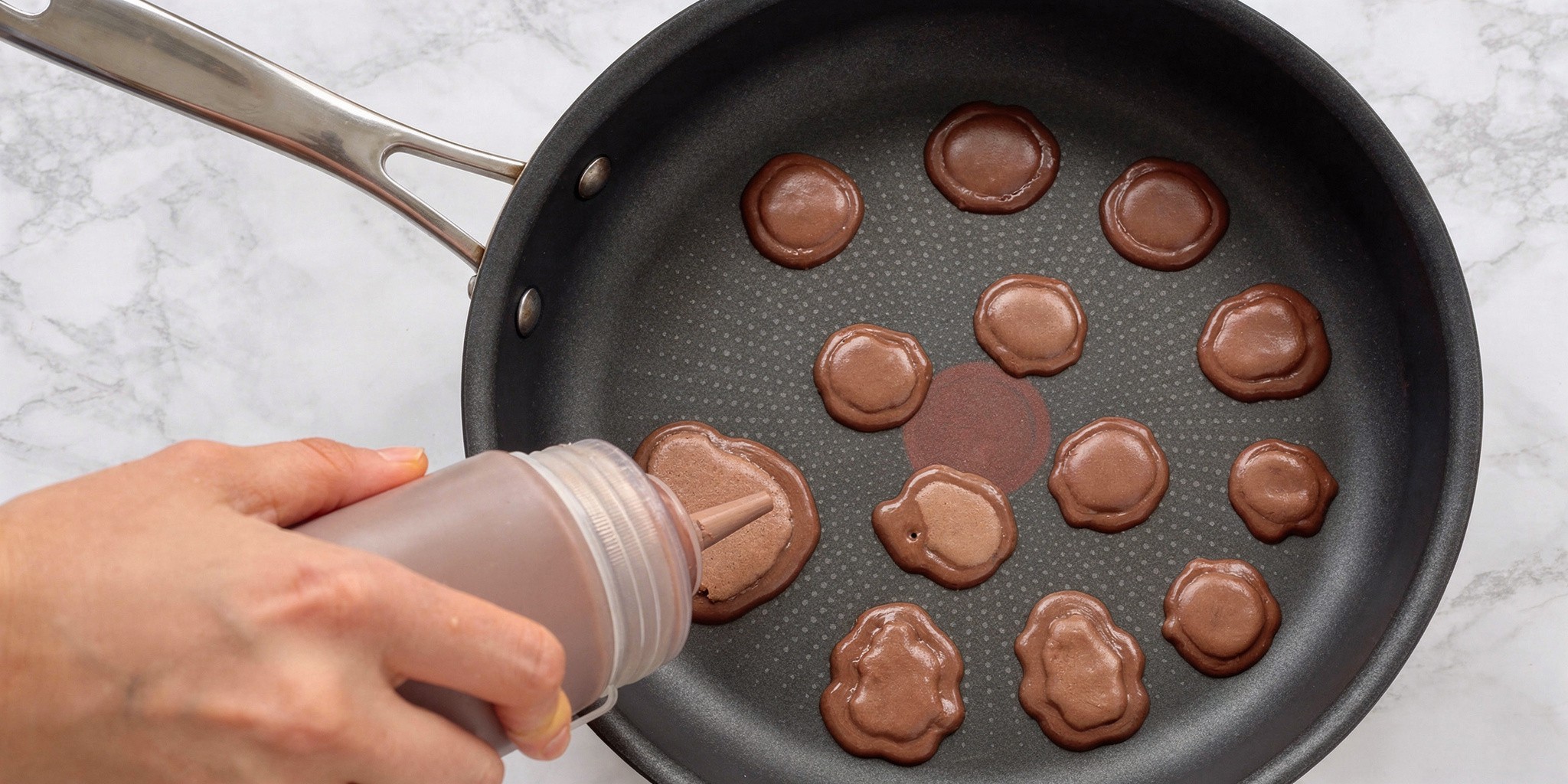 Леопардовые блины, рецепт: Выдавите несколько порций светло-коричневого теста, сделайте каёмку из тёмного теста