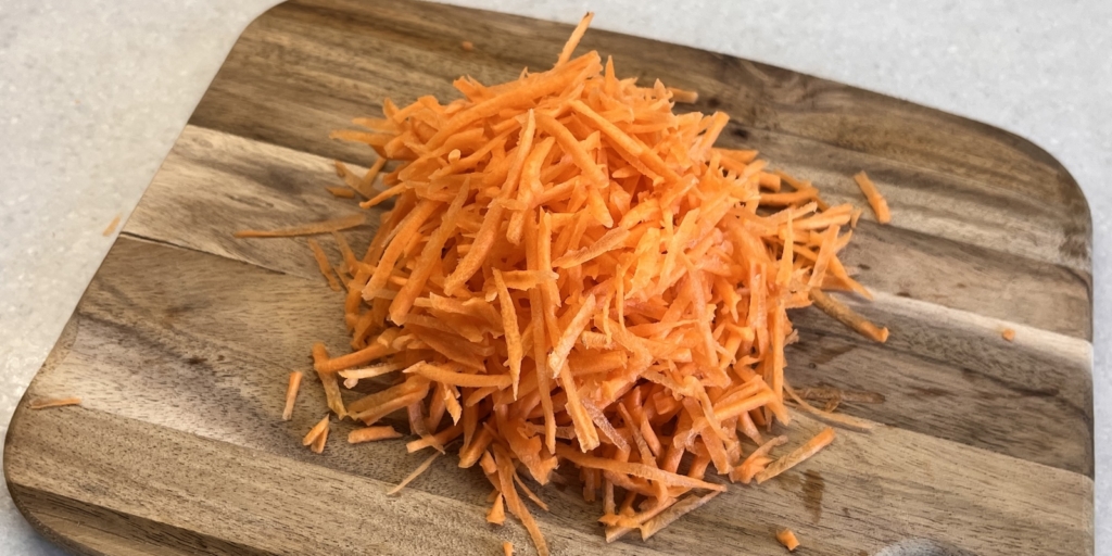 Лапша вок с курицей, овощами и грибами: Натрите морковь